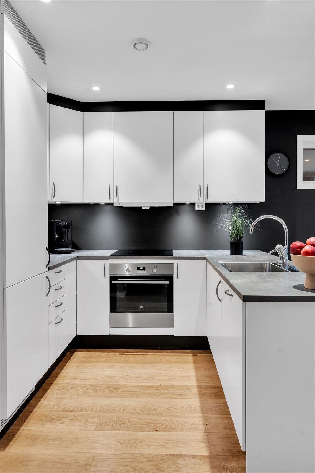 Tidløst og moderne kjøkken i hvit utførelse, med rikelig skap- og benkeplass. Galleribilde