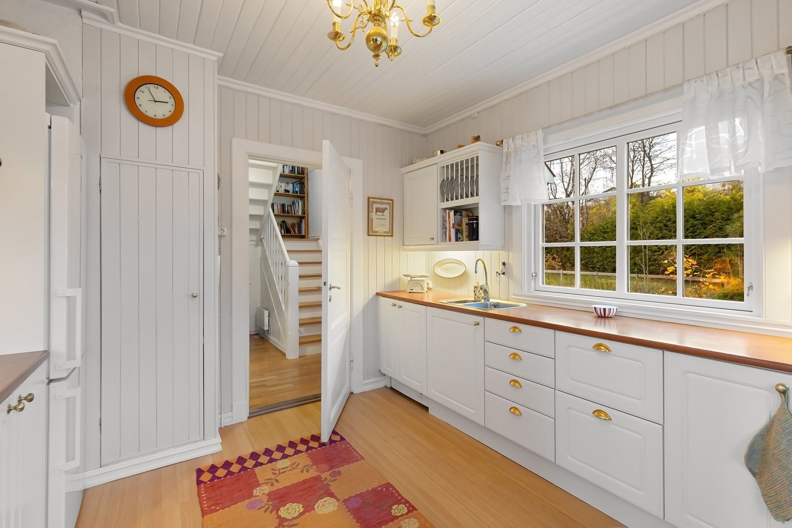 Praktisk opplegg for vaskemaskin er montert i et hjørneskap. Galleribilde