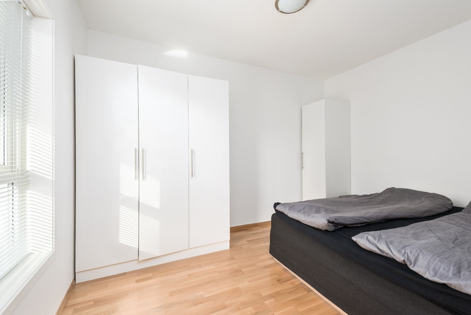 Soverom med garderobeskap og seng. Galleribilde