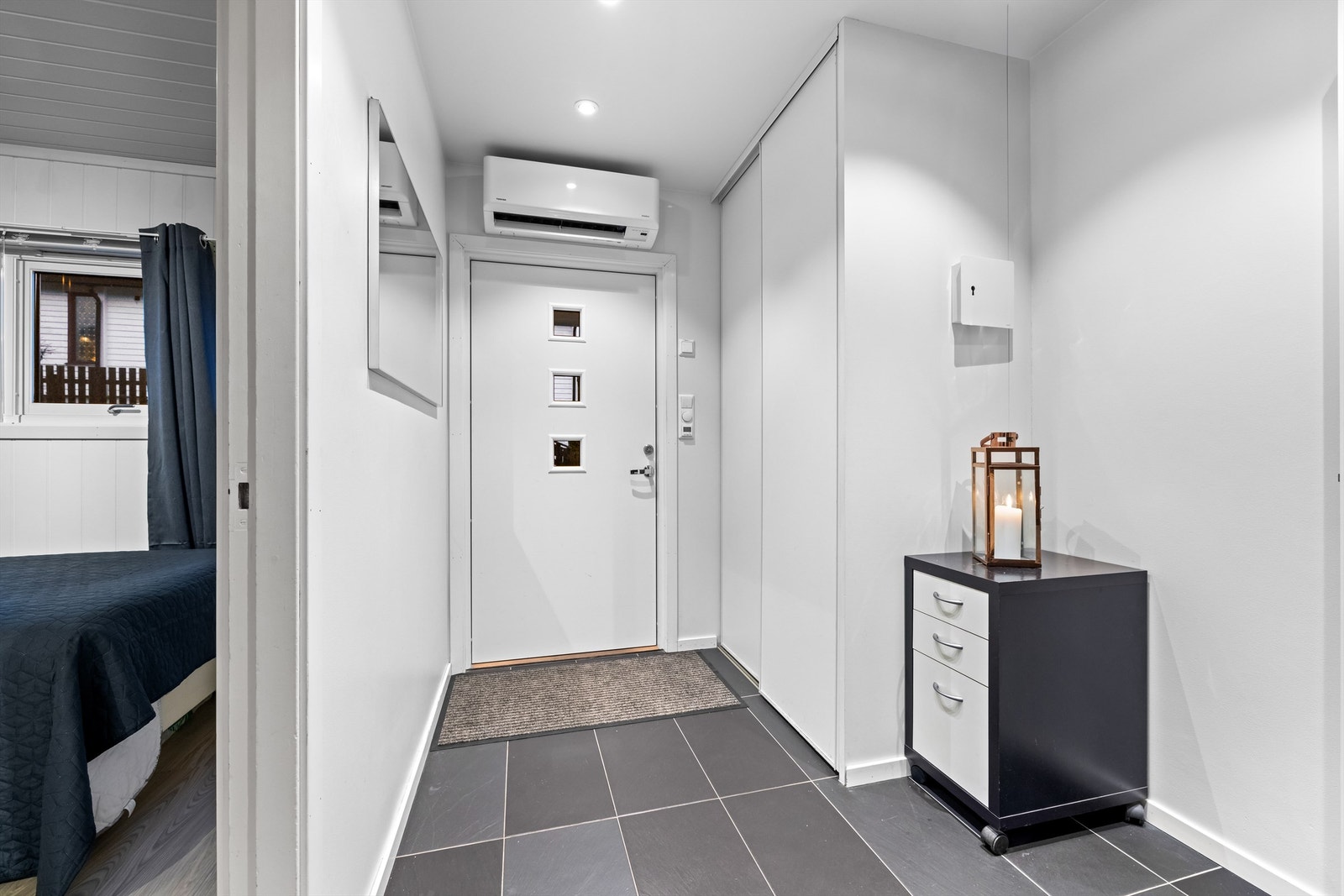 Innbydende entré med flislagt gulv og gulvvarme for ekstra komfort. I tillegg er det montert varmepumpe her. Galleribilde