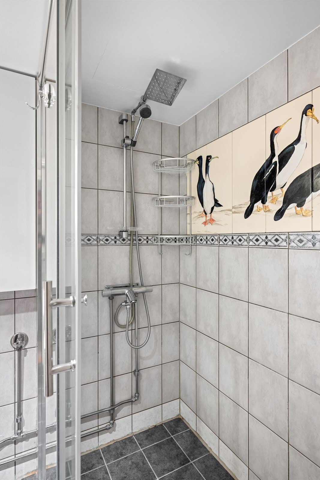 Dusjnisje med skyvedør av glass og dusjarmatur med både hånddusj og regndusj. Badet er gitt TG3 i tilstandsrapporten. Galleribilde