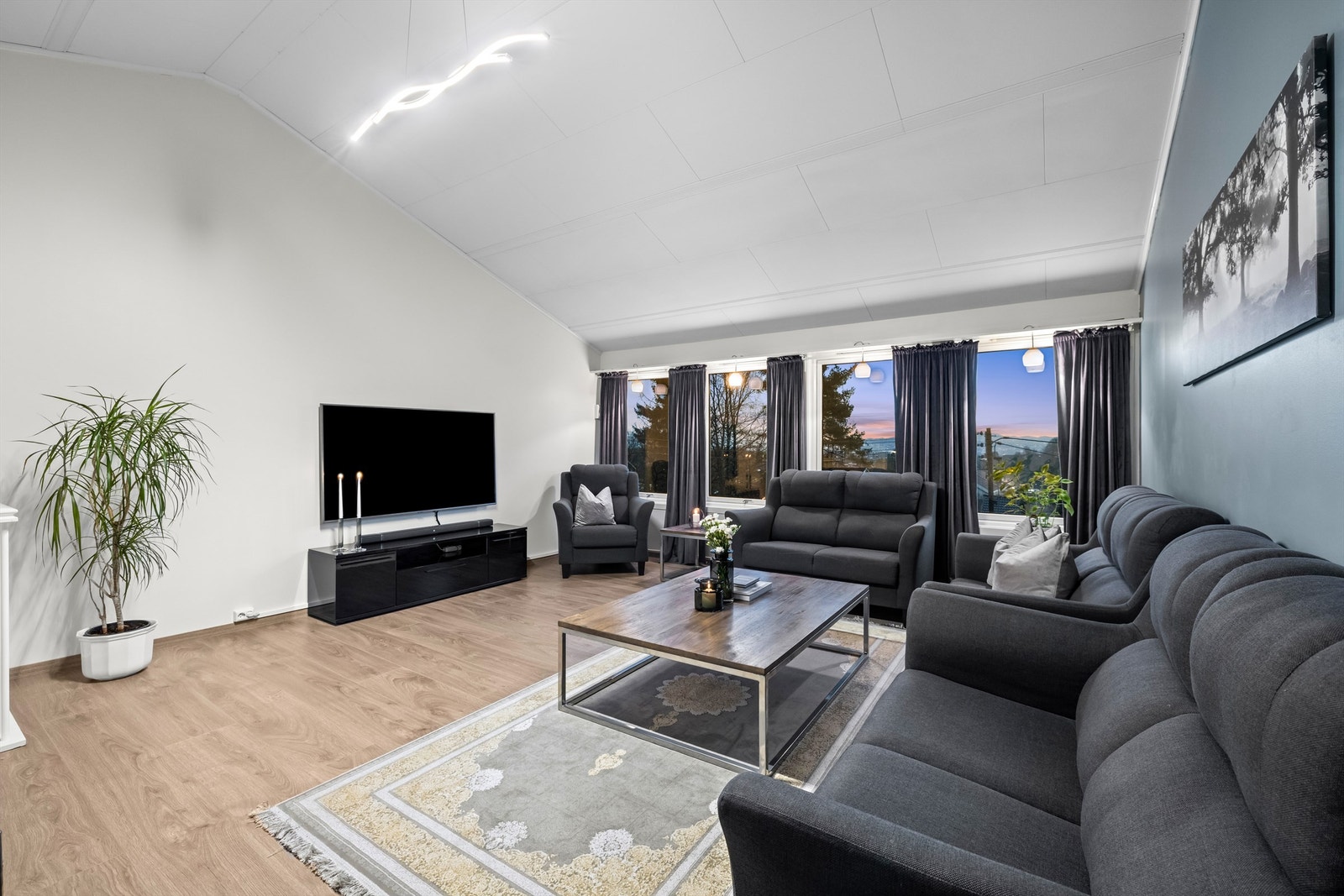 Stuen i øverste plan er et lyst og romslig samlingspunkt med god plass til flere sittegrupper. Galleribilde