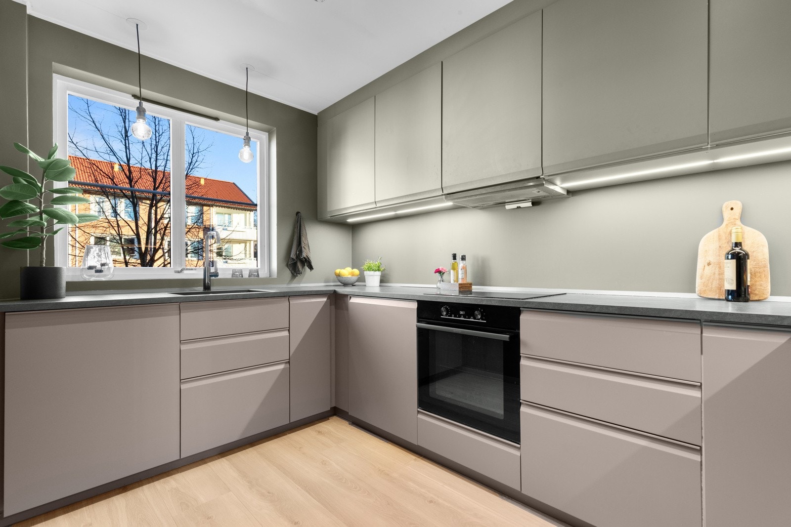 Innredningen har glatte fronter og laminert benkeplate med planlimt oppvaskkum. Praktisk med god belysning under de takhøye overskapene. Galleribilde