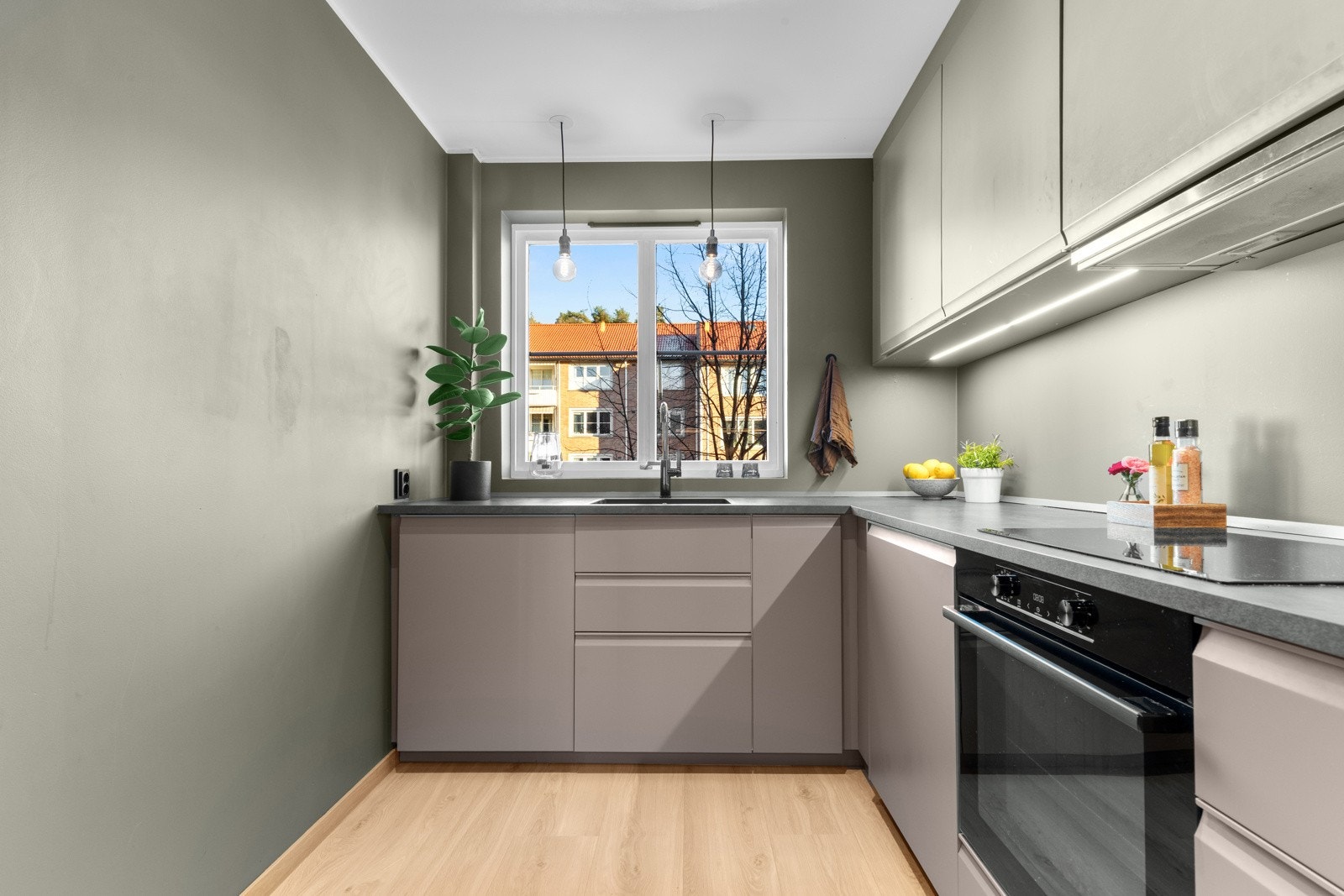 God standard fra 2023 med lys enstavs laminat på gulv, glatte overflater malt i en fin grønnfarge og skjult elektrisk anlegg. Galleribilde