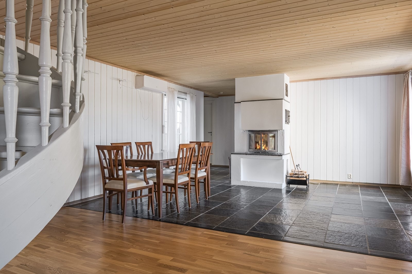 Midt i stuen er det en peis med innsats som gir god varme og hygge, og er et fint supplement til varmepumpen. Galleribilde