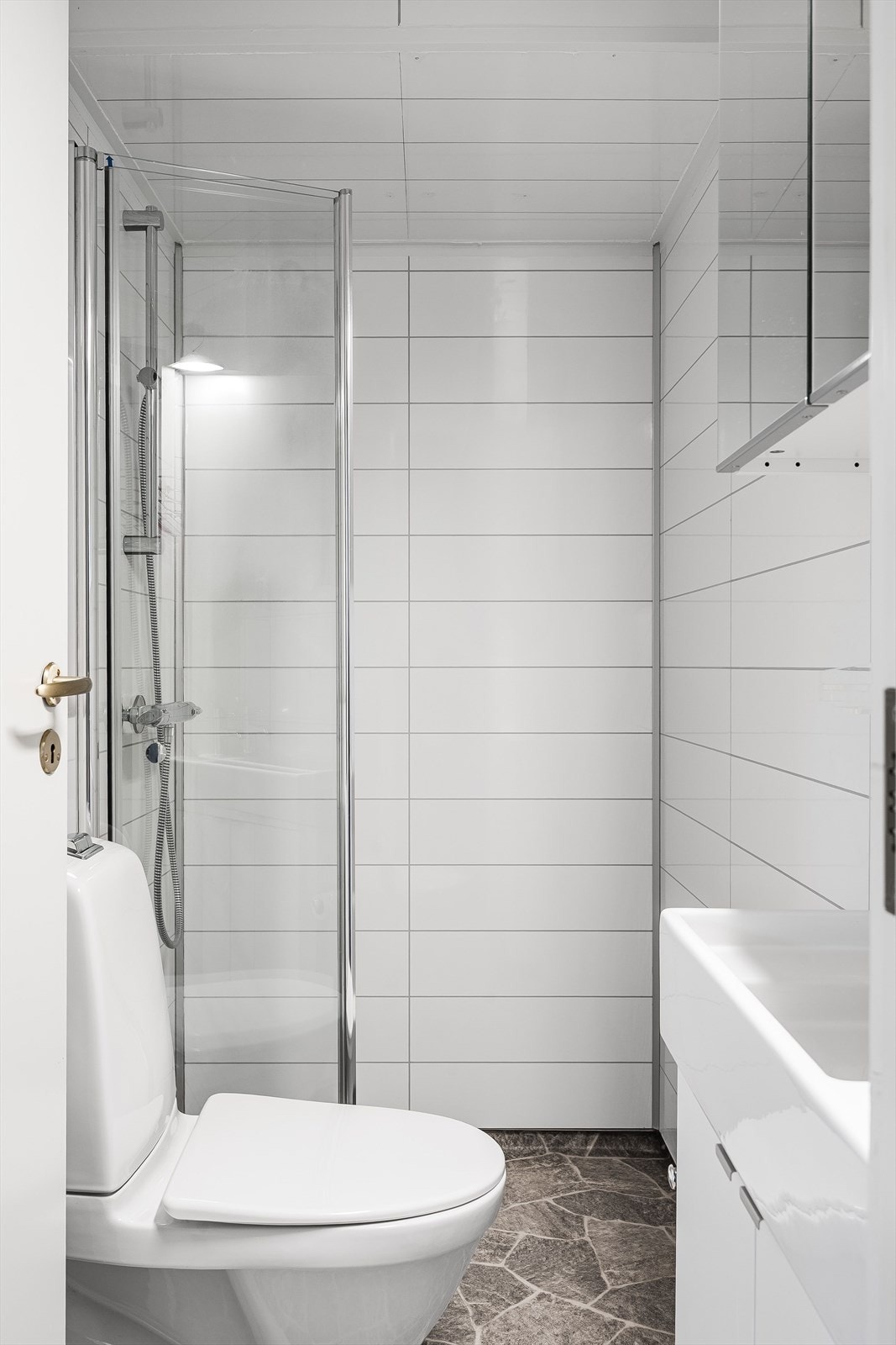 Badet i den opprinnelig delen er innredet med vinyl på gulv og baderomsplater på vegger. Baderommet er innredet med dusjhjørne med innfellbare dører, heldekkende servant nedfelt i benkeskap, speilskap og frittstående toalett. Galleribilde