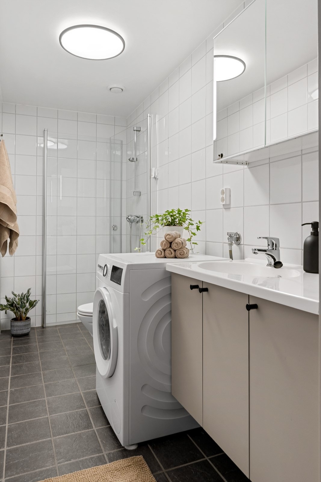 Flislagt og tidsriktig bad med varme i gulv, opplegg til vaskemaskin og dusjhjørne med innfellbare vegger. Galleribilde