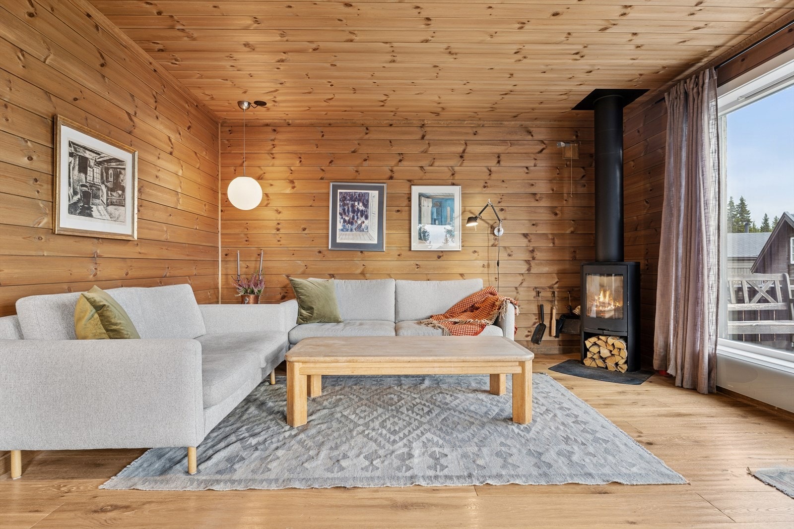 Hytta fremstår lys og innbydende, med panel på vegger og i tak som gir en varm og autentisk hytteatmosfære. Galleribilde