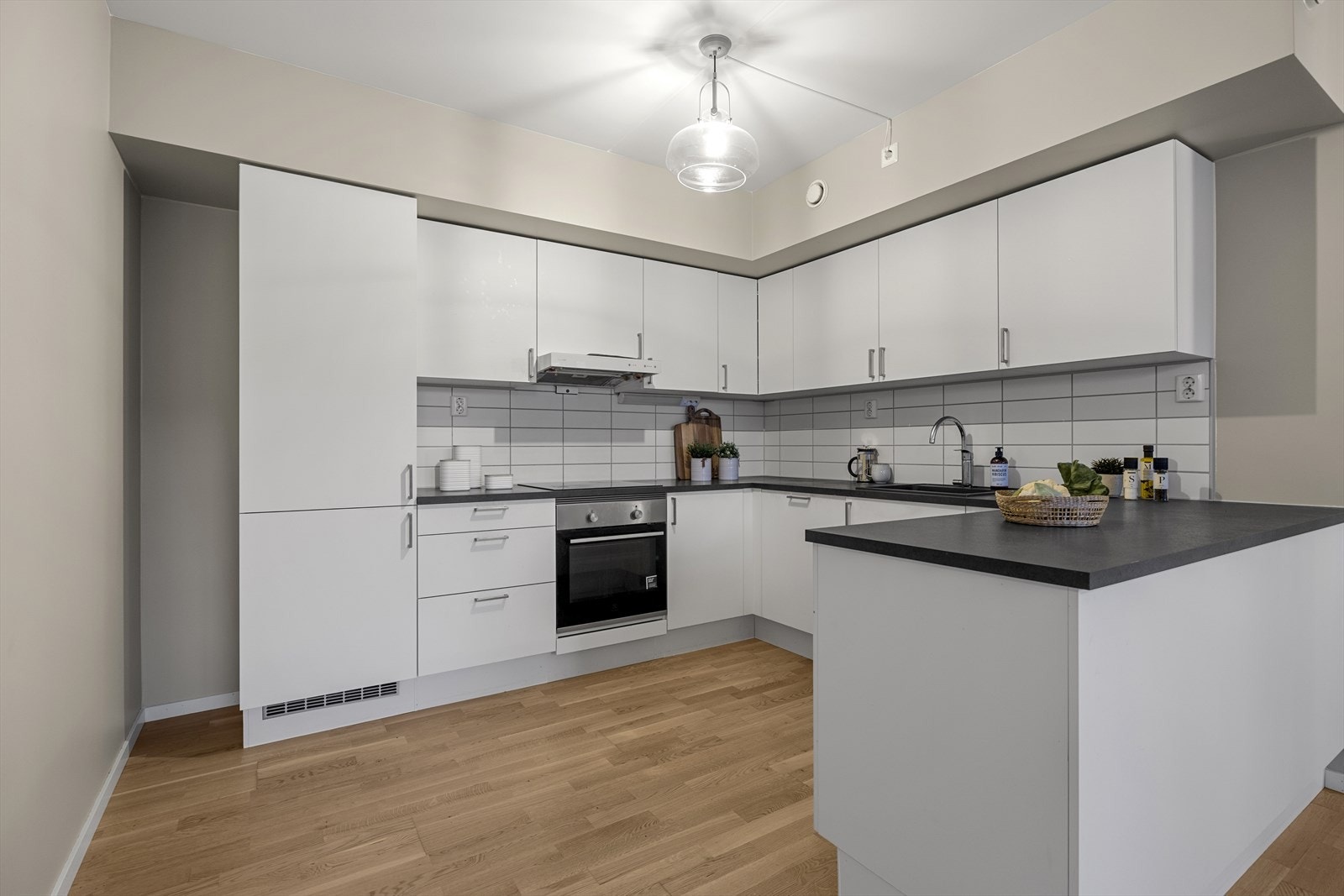 Kjøkkeninnredningen har glatte fronter, mørk benkeplate, nedfelt oppvaskkum og 1-greps blandebatteri. Galleribilde