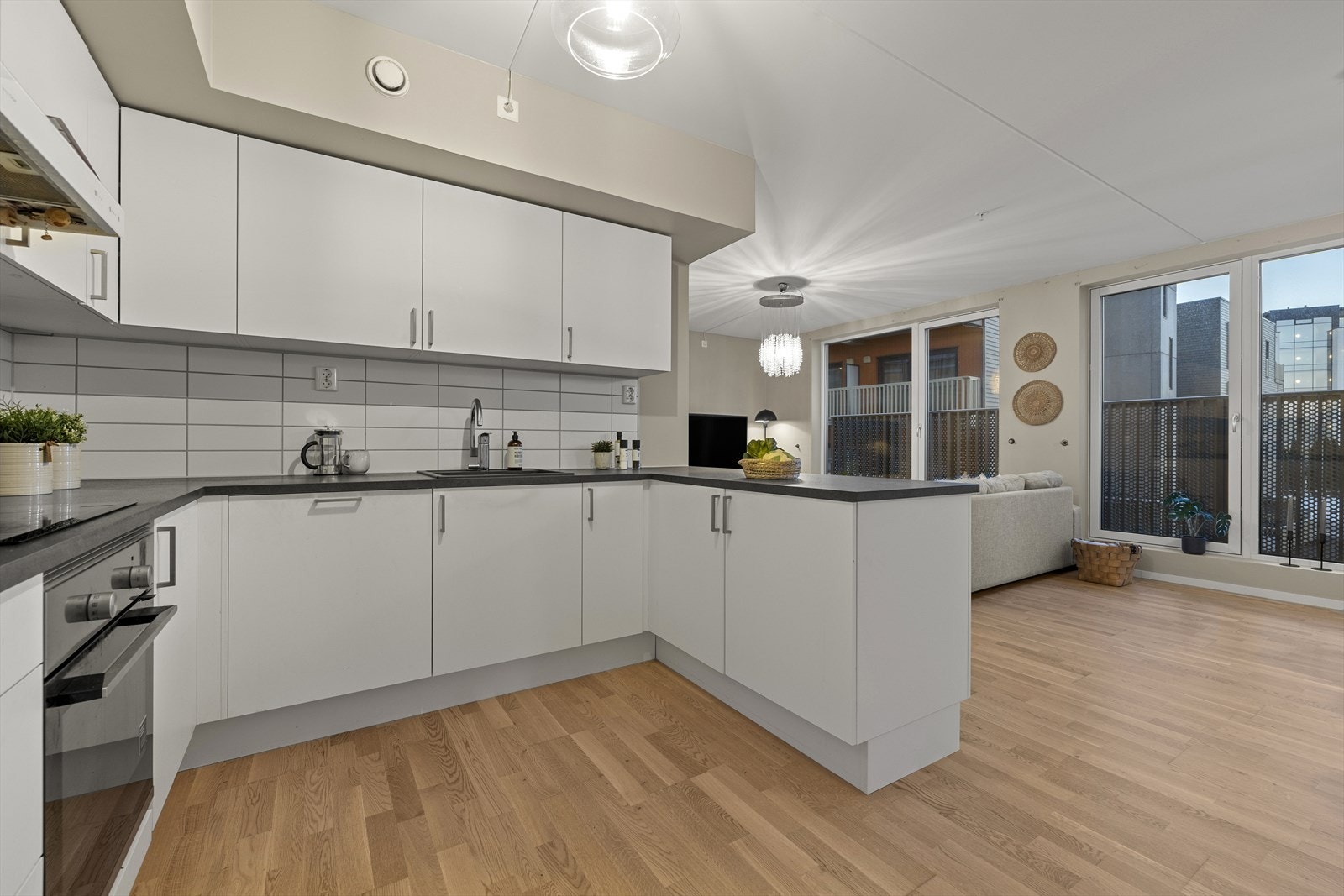 Flis over benk. Videre er det satt integrerte kjøl-/fryseskap, oppvaskmaskin, ovn og platetopp. Det er tilkoblet mekanisk avtrekk over platetoppen. Galleribilde