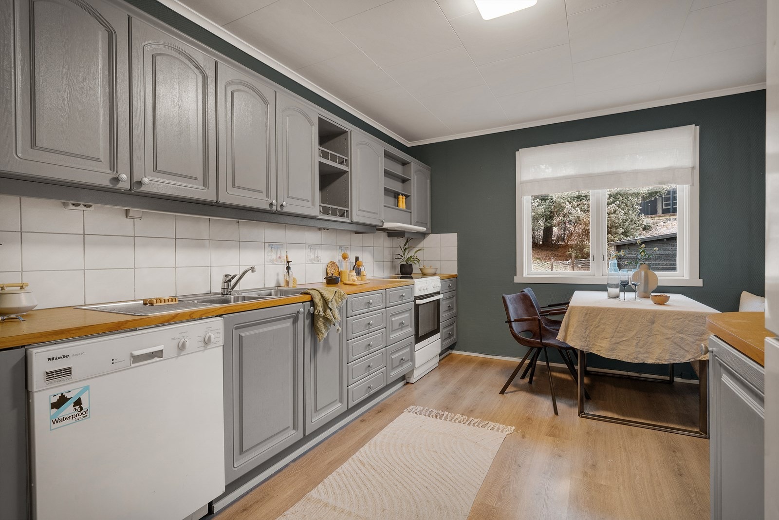 Kjøkkenet er et klassisk Husebykjøkken fra ca. 1990, med nymalte fronter Galleribilde