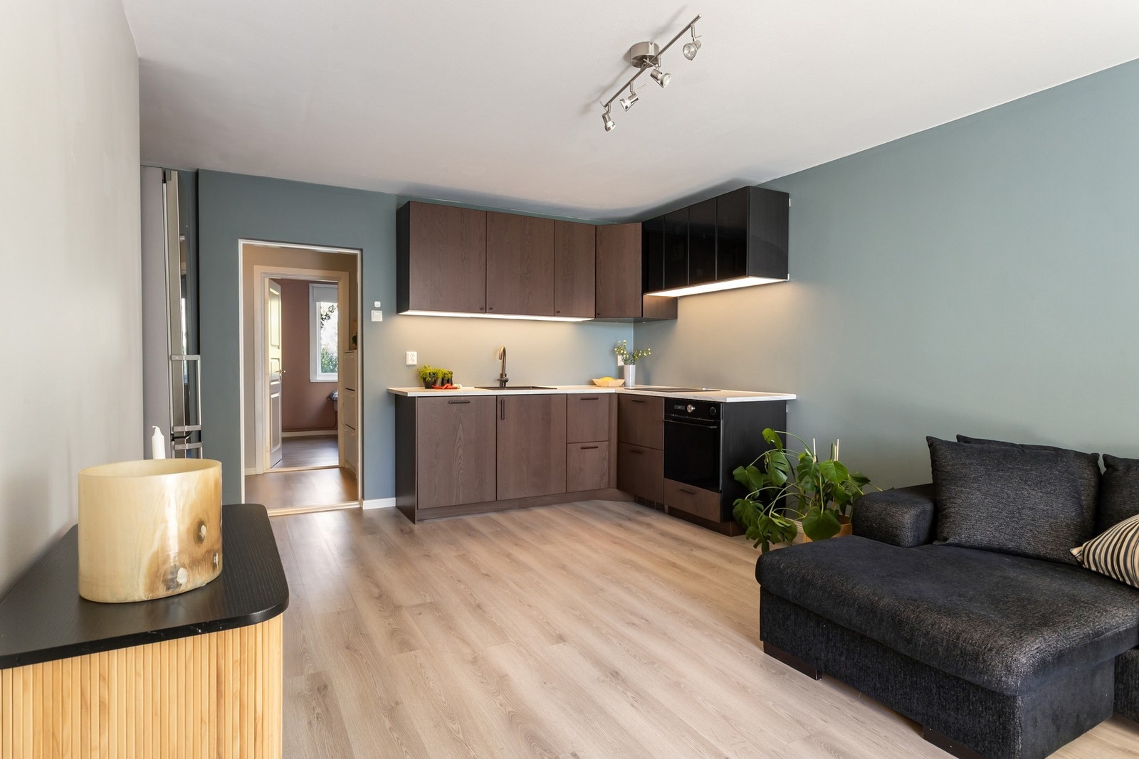 Lekker kjøkkeninnredning fra 2022 med mørke laminerte fronter og overskap med sorte glassfronter. Galleribilde