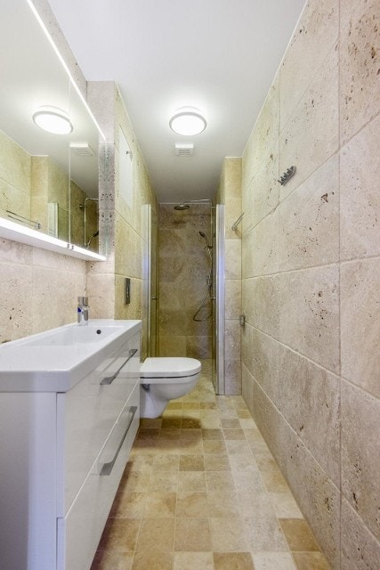 Flislagt bad med oppbevaring under servant. Galleribilde