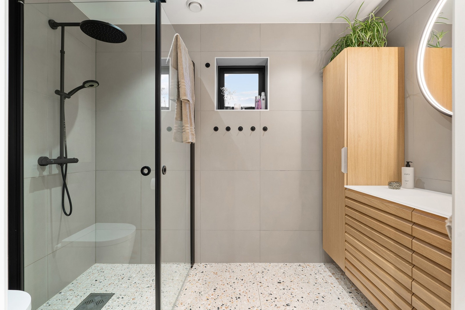 Delikat flislagt bad, fra Linnbad. Stilig dusjhjørne med både håndholdt og regndusj. Galleribilde