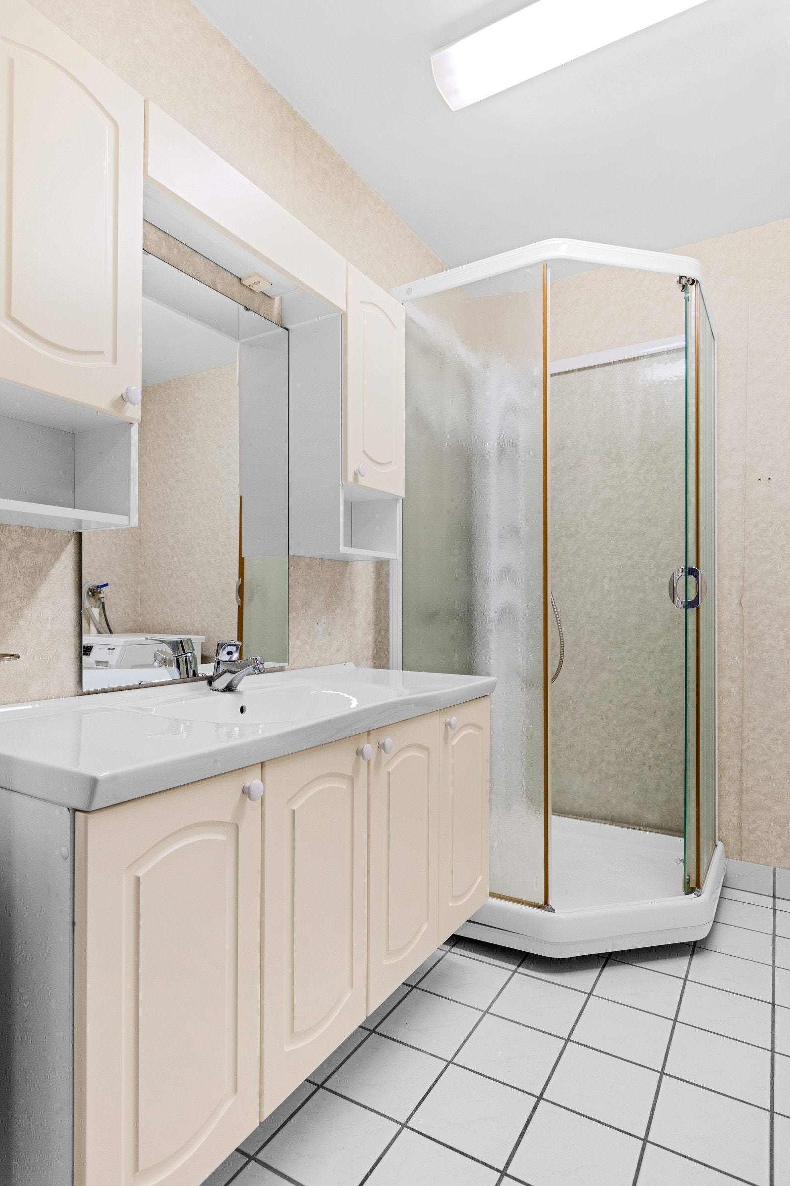 Badet har fliser på gulv og tapet på vegg Galleribilde