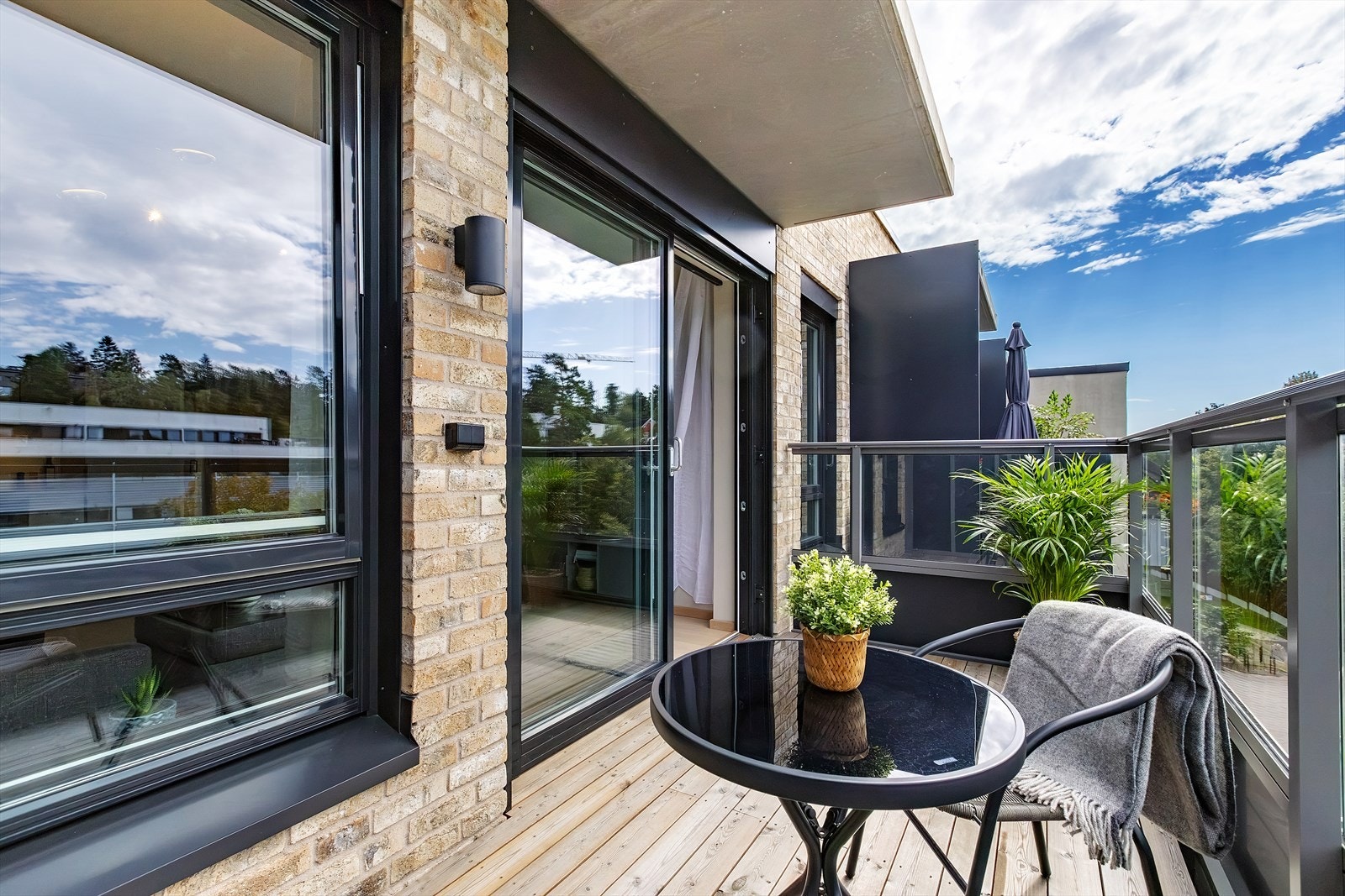 På sommerstid fungerer balkongen som en forlengelse av stuen, med god plass til utemøbler og diverse småbeplantning. Galleribilde