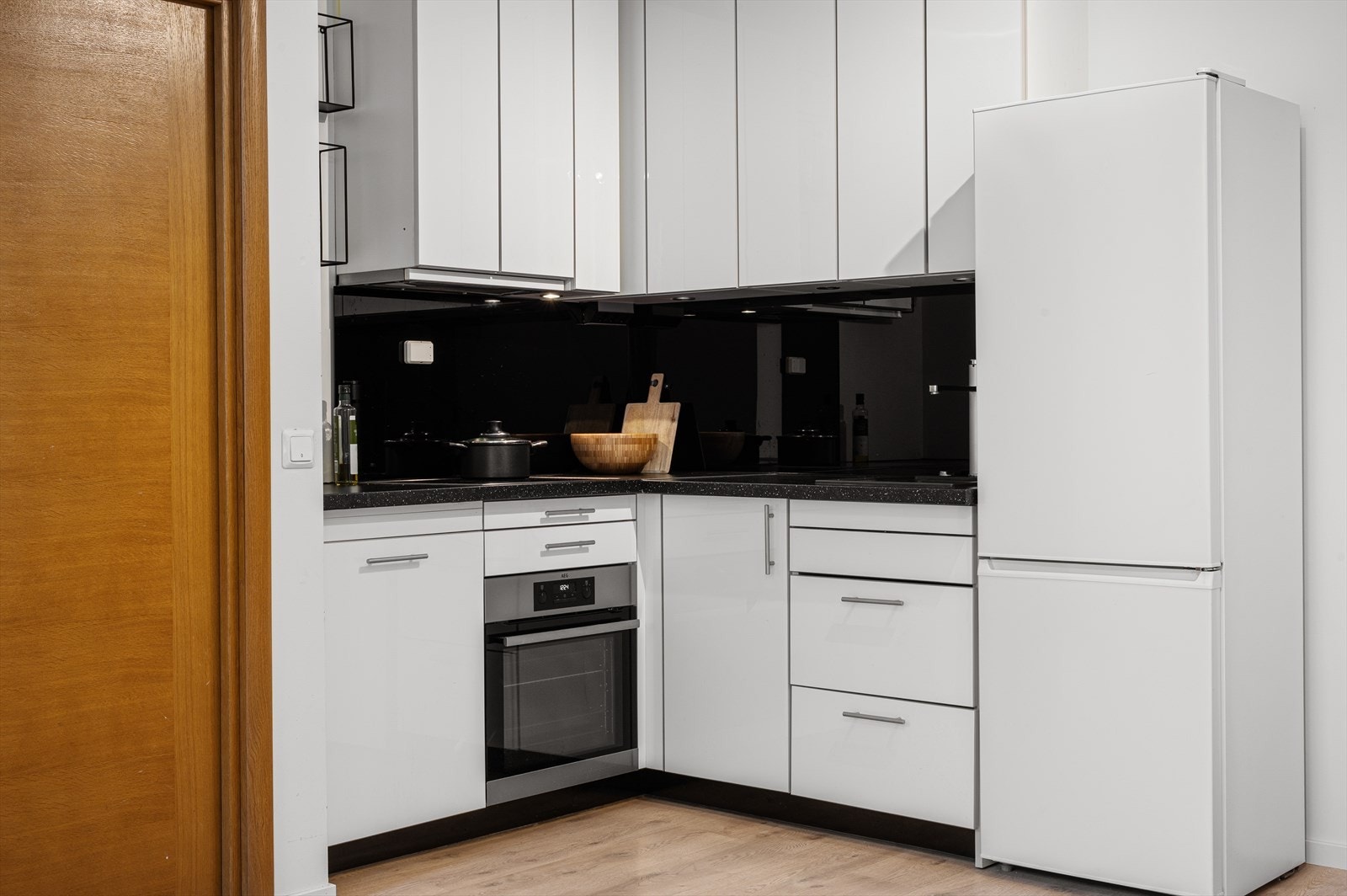 Pent og pratisk kjøkken med slette fronter og laminat benkeplate. Galleribilde