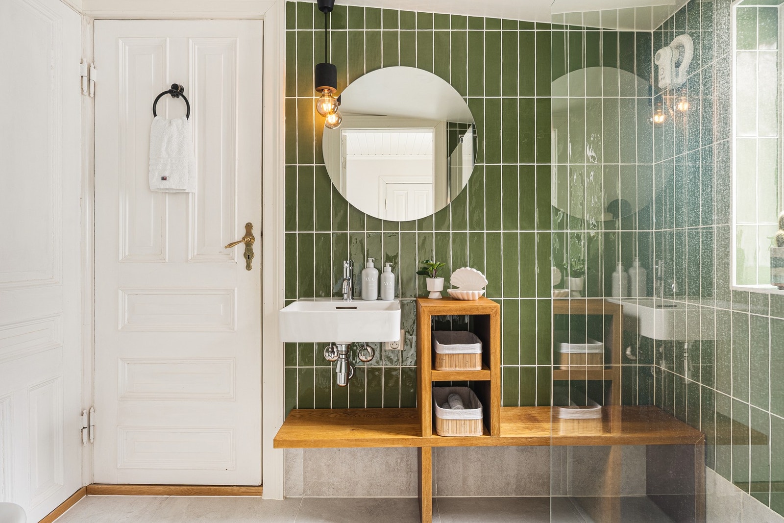 Badet er helfliset og oppgradert med moderne innredning, vegghengt toalett, dusj med glassvegger, servant, speil og belysning. Galleribilde