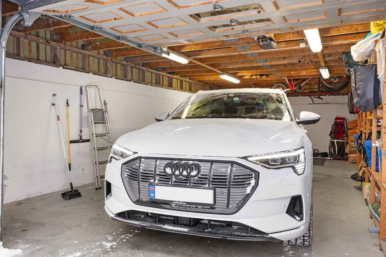 Garasjen er solid oppført med støpt gulv, leddport i metall og praktisk utforming som gjør den enkel å bruke. I tillegg er det installert elbillader, noe som gir en moderne og fremtidsrettet løsning for bilhold. Galleribilde
