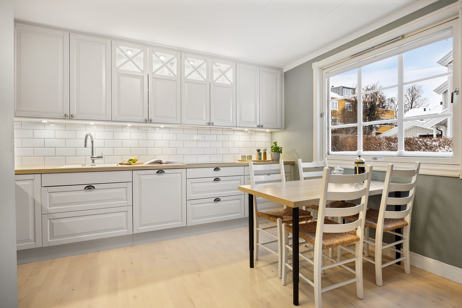 Enkelte overskap har dekorative glassfronter som tilfører et elegant preg. Integrert belysning både i og under overskapene skaper en behagelig atmosfære og god arbeidslys. Galleribilde