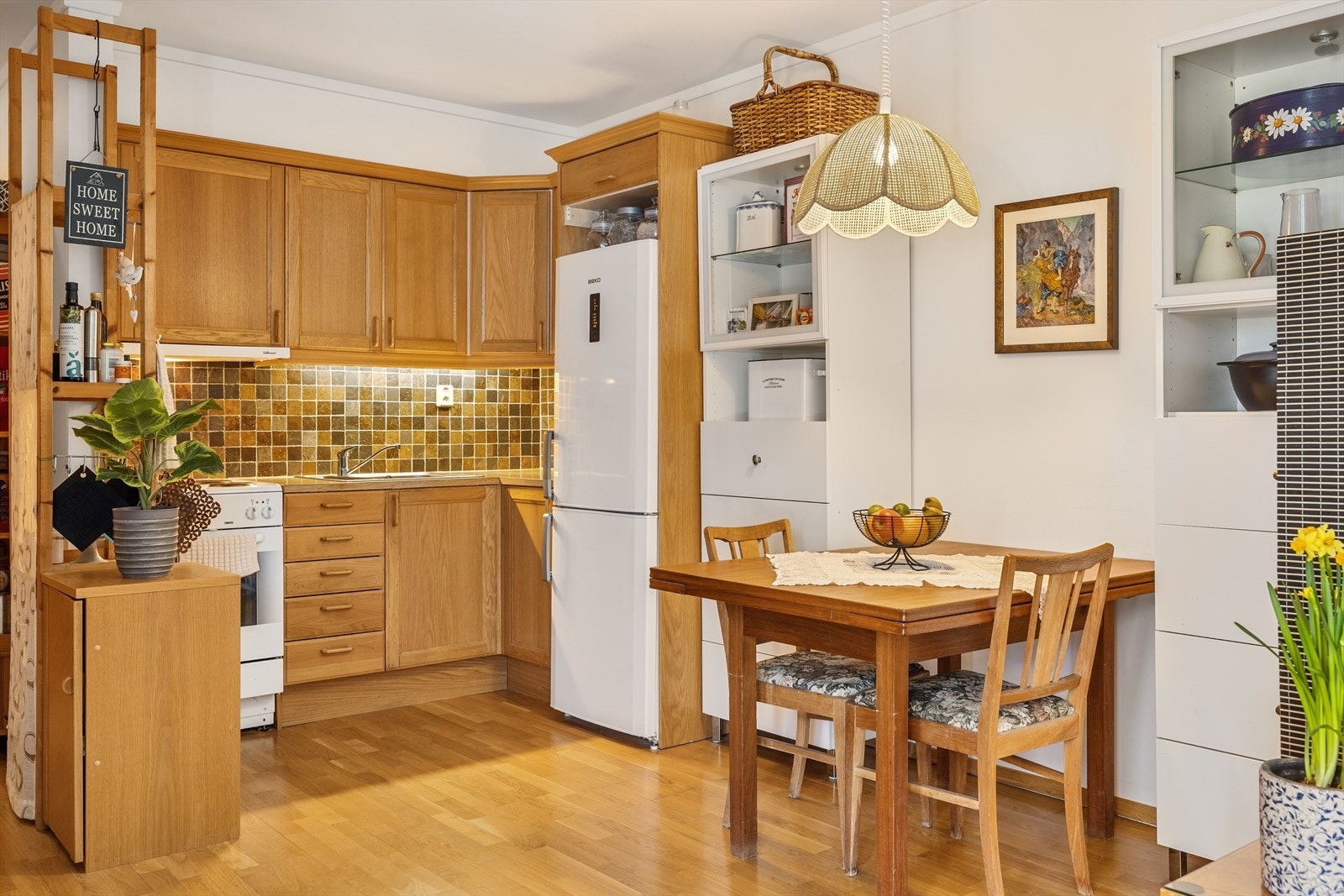 Kjøkkenet har innredning fra Norema med profilerte fronter av heltre eik og laminert benkeplate. Det er fliser i benkeryggen. Det er plass til frittstående komfyr og kjøleskap. Galleribilde