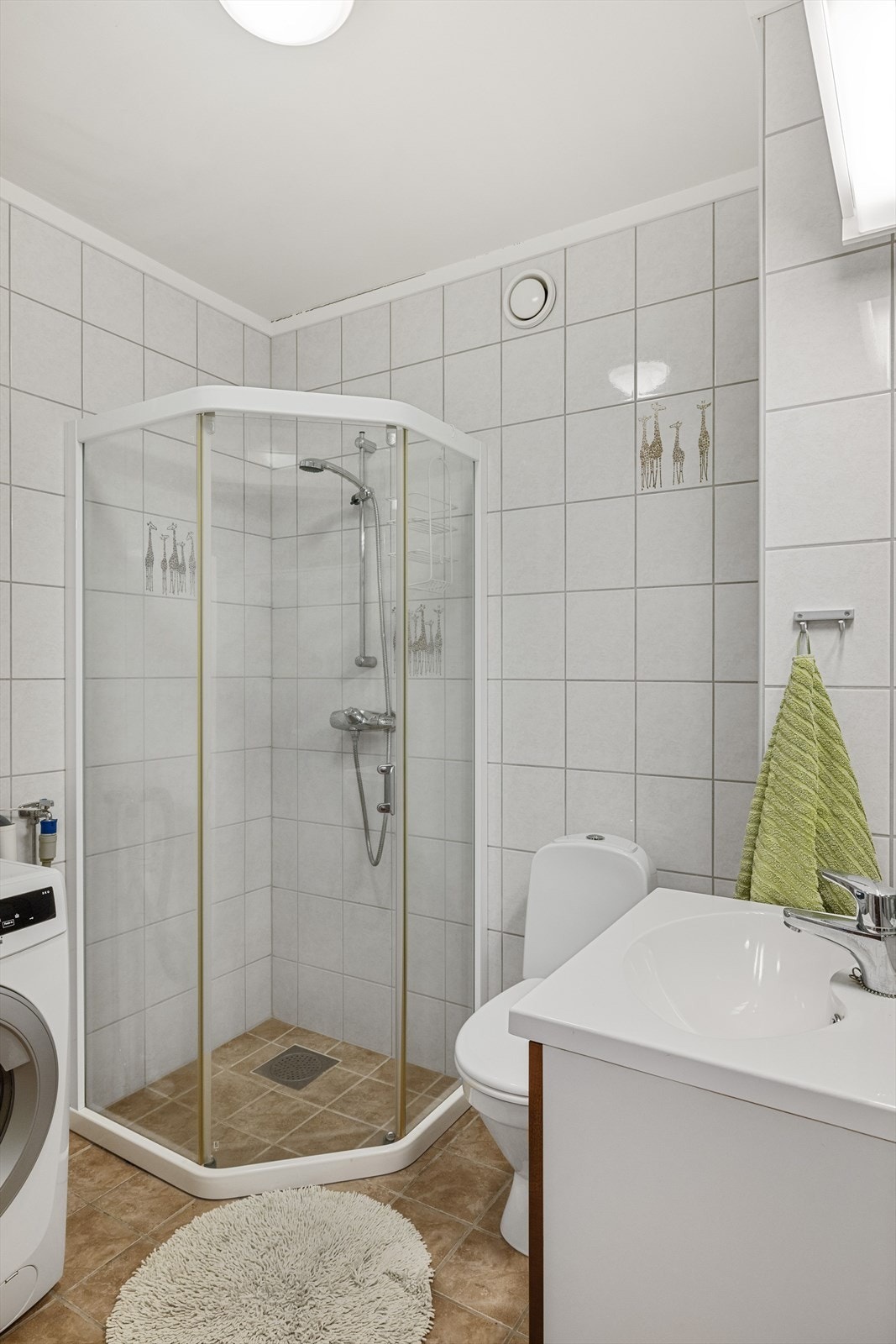 Flialsgt bad med gulvvarme. Rommet har dusj med vegghengt dusjbatteri, gulvmontert toalett, baderomsinnredning med heldekkende servant og opplegg til vaskemaskin. Galleribilde