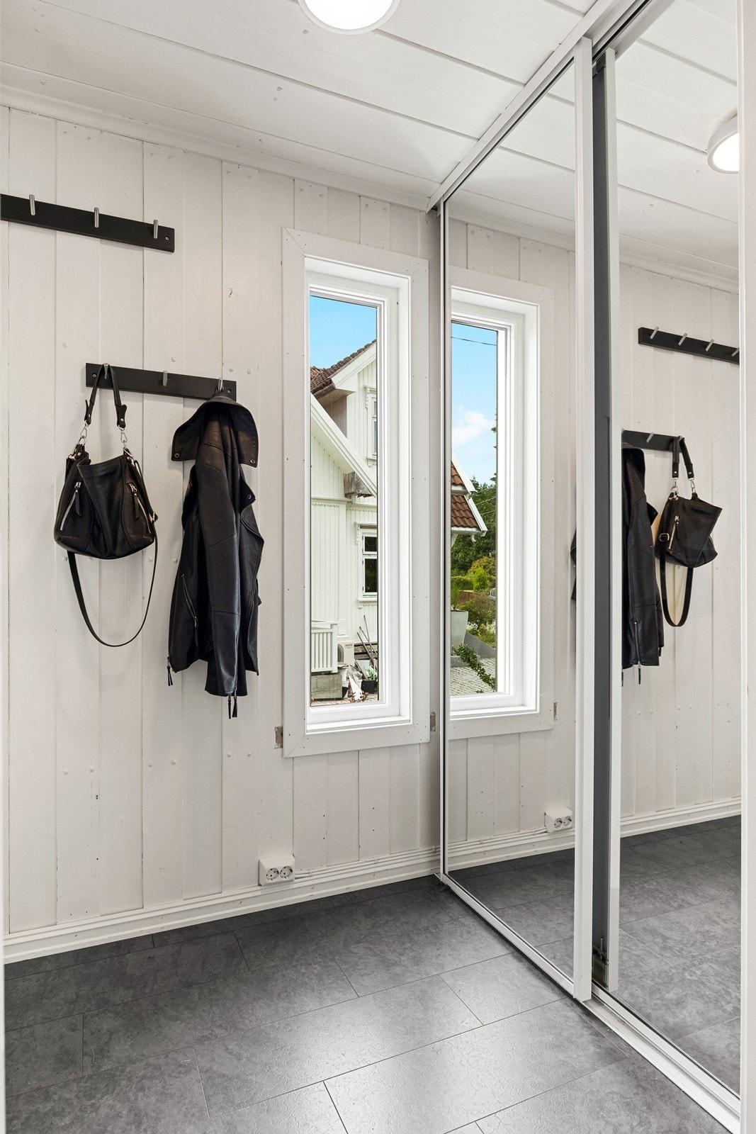 Velkommen inn! Entré med god plass til å henge fra seg yttertøy og lignende. Praktisk skyvedørsgarderobe med speil som bidrar til en luftig følelse når man kommer inn. Galleribilde