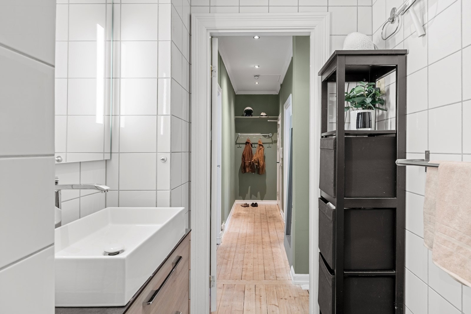 Innredning bestående av innfellbare dusjdører, naturlig avtrekk, servantskap og veggmontert wc. Galleribilde