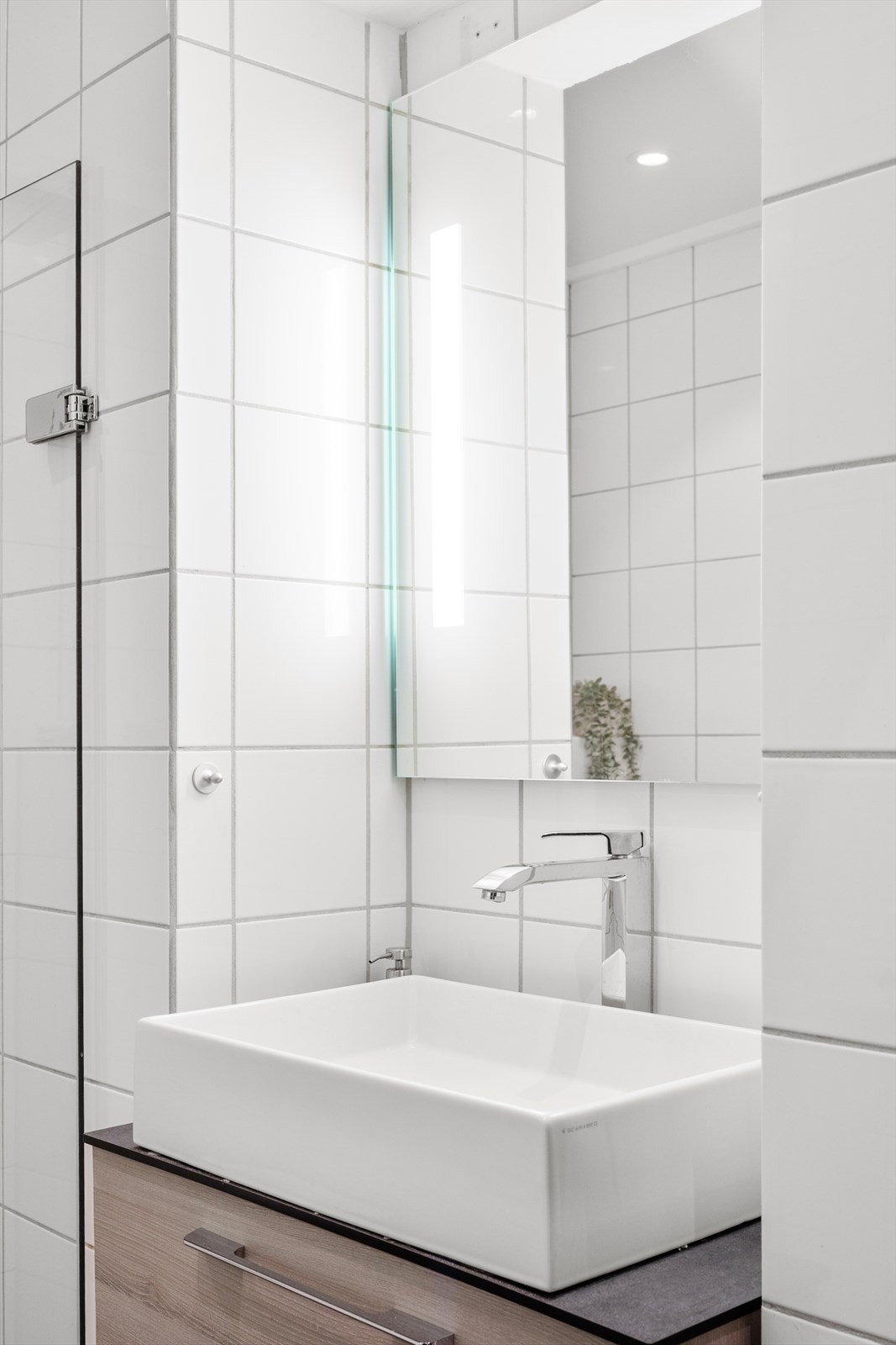 Badet har flislagt gulv og vegger, downlights i taket med malt himling. Det er gulvvarme. Galleribilde