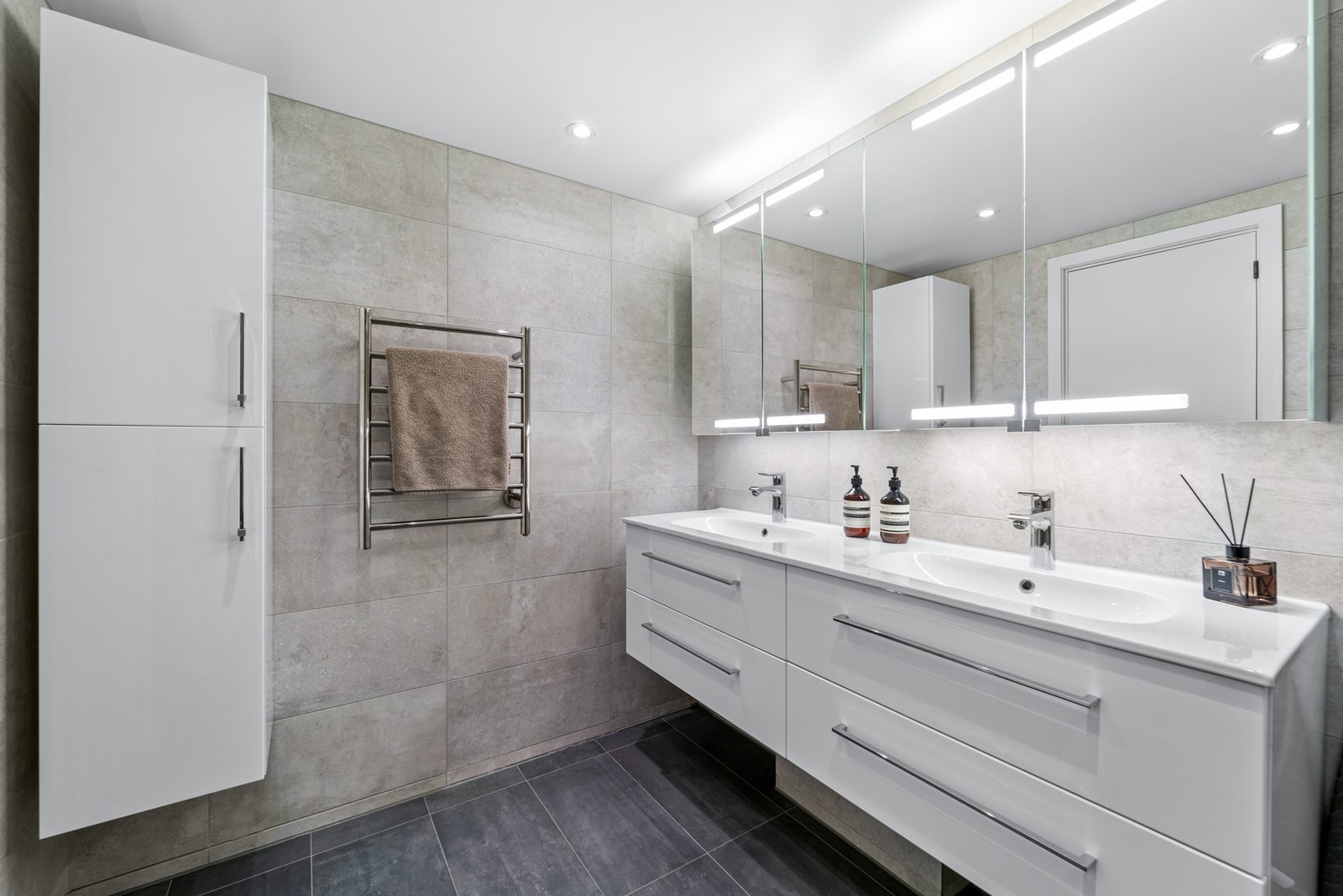 Badet er fra 2015 og har flislagte overflater og moderne innredning med benkeskap, høyskap og speilskap med belysning. Galleribilde