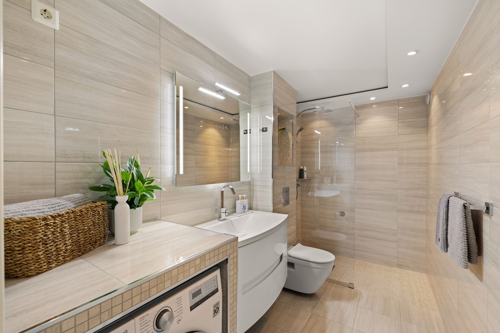 Delikat bad fra 2015 med flislagt gulv med varmekabler og flislagte vegger. Downlights belysning i tak. Galleribilde