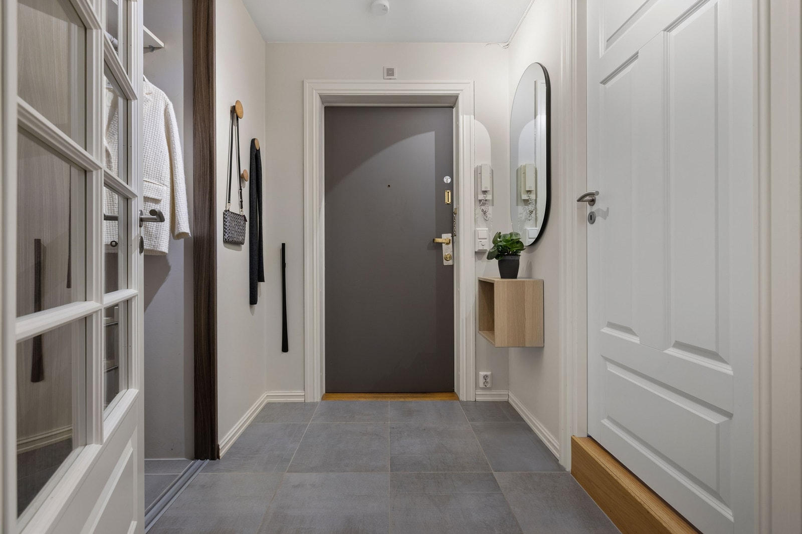 Lys og innbydende entré med flislagt gulv som gir et svært godt førsteinntrykk av leiligheten. Galleribilde