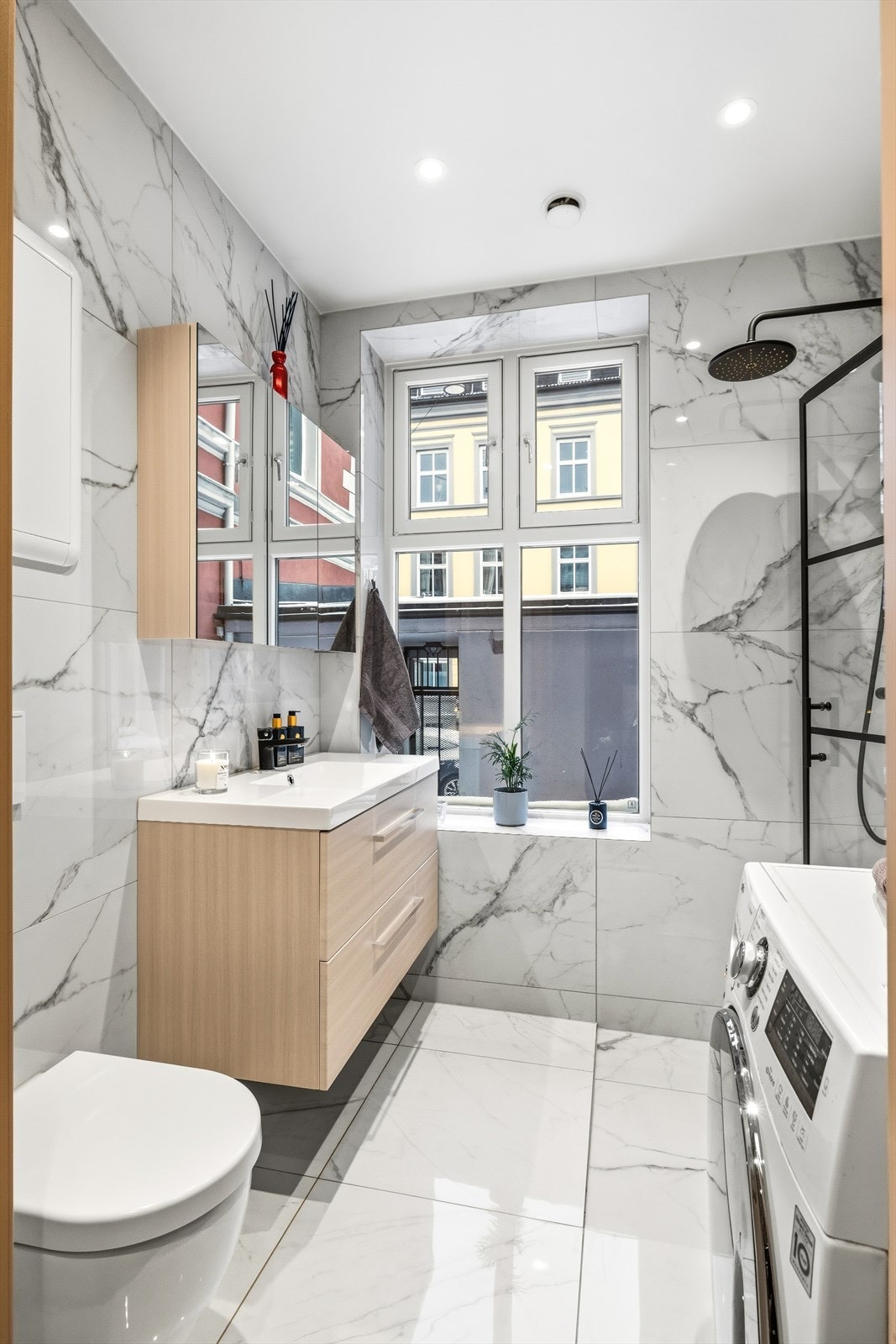 Lyst og moderne bad med opplegg for vaskemaskin Galleribilde