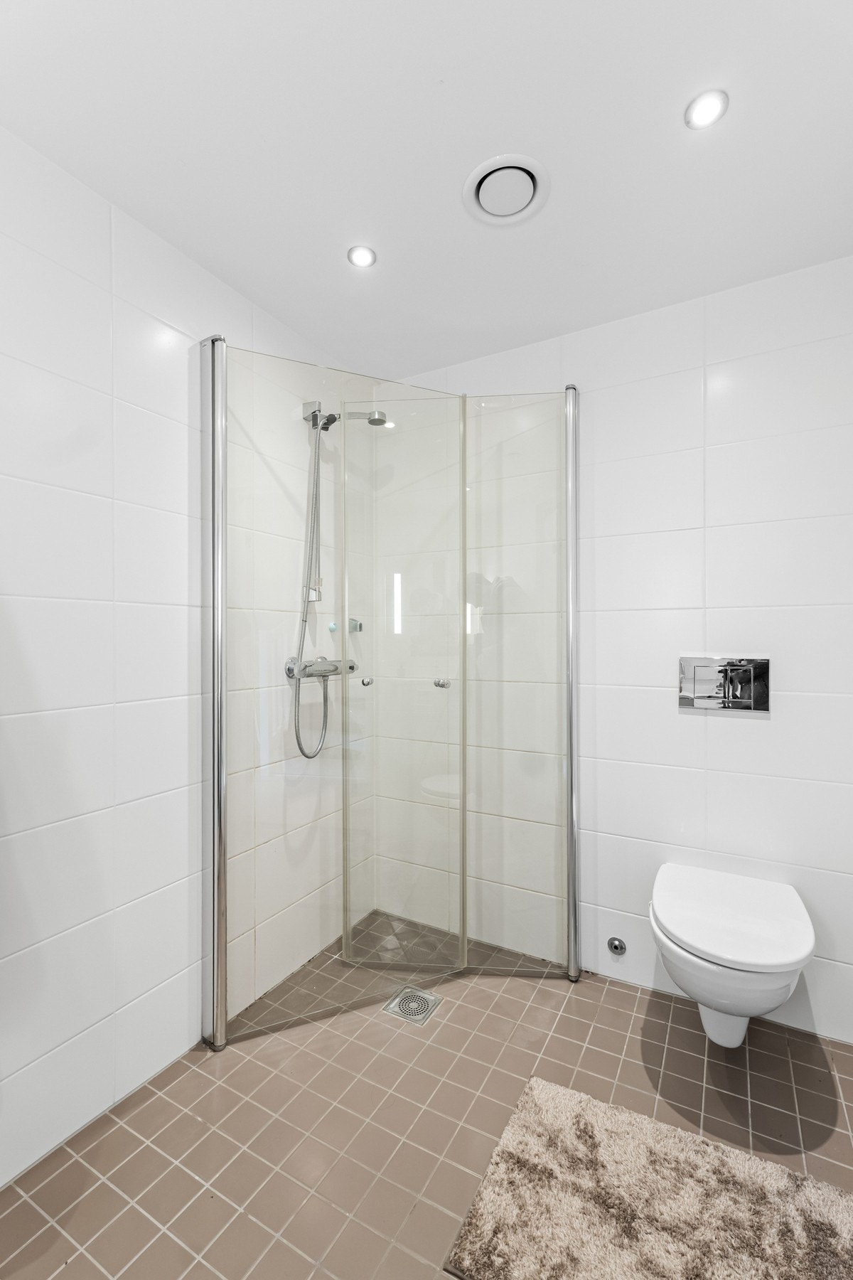 Baderom i 2.etasje med dusjnisje og flislagt gulv i moderne farger. Galleribilde