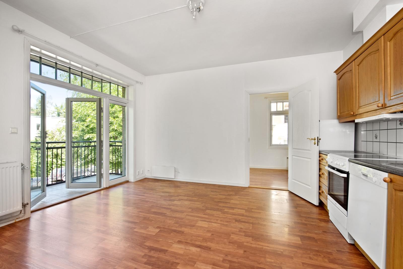 Stue med åpen kjøkkenløsning. Soverommene ligger på hver sin side av stuen Galleribilde