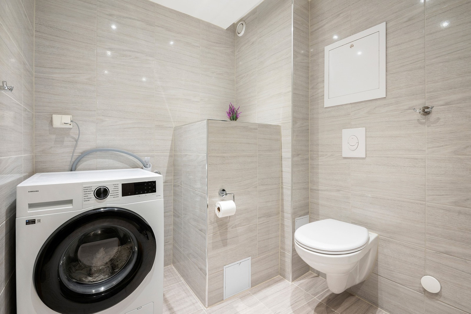 Badet har vegghengt toalett samt opplegg for vaskemaskin. Galleribilde