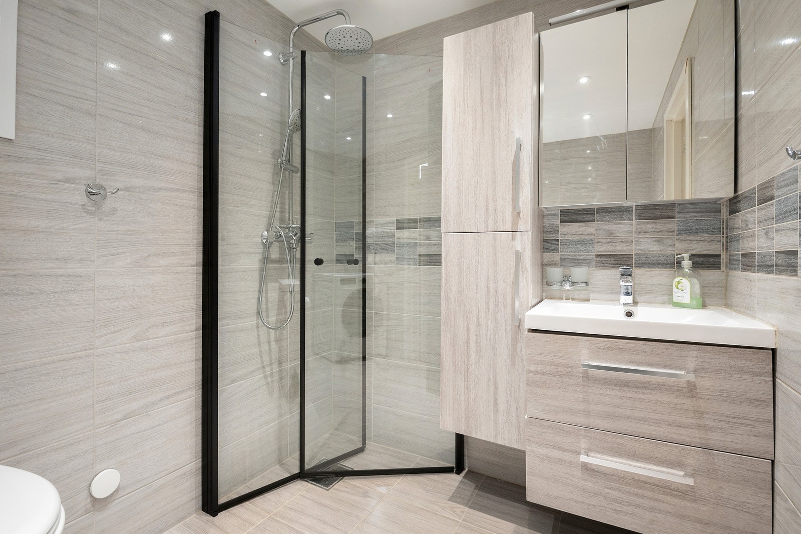 Bad fra 2019 med flislagt gulv og vegger i lyse, moderne toner. Varme i gulv. Galleribilde