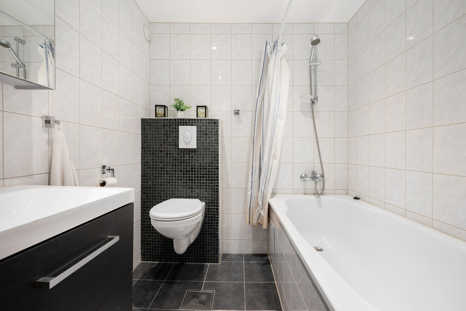 Det andre badet er fra 2019 med vegghengt servantskap og speilskap over servant, samt vegghengt toalett og innbygget badekar. Galleribilde