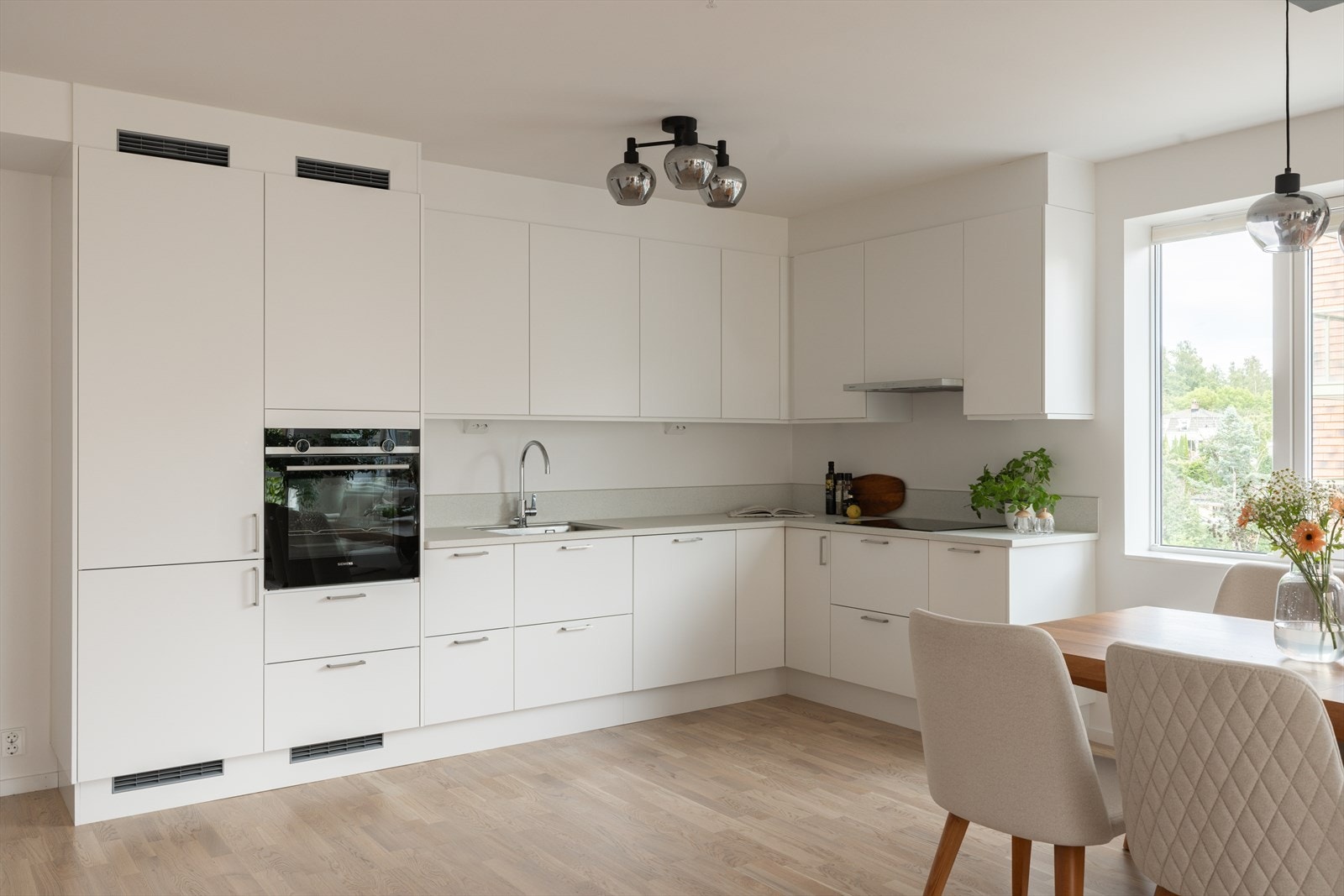 Plassering i L-form sørger for god arbeidsflyt, bra med oppbevaringsplass og mulighet for sosial matlaging. Galleribilde