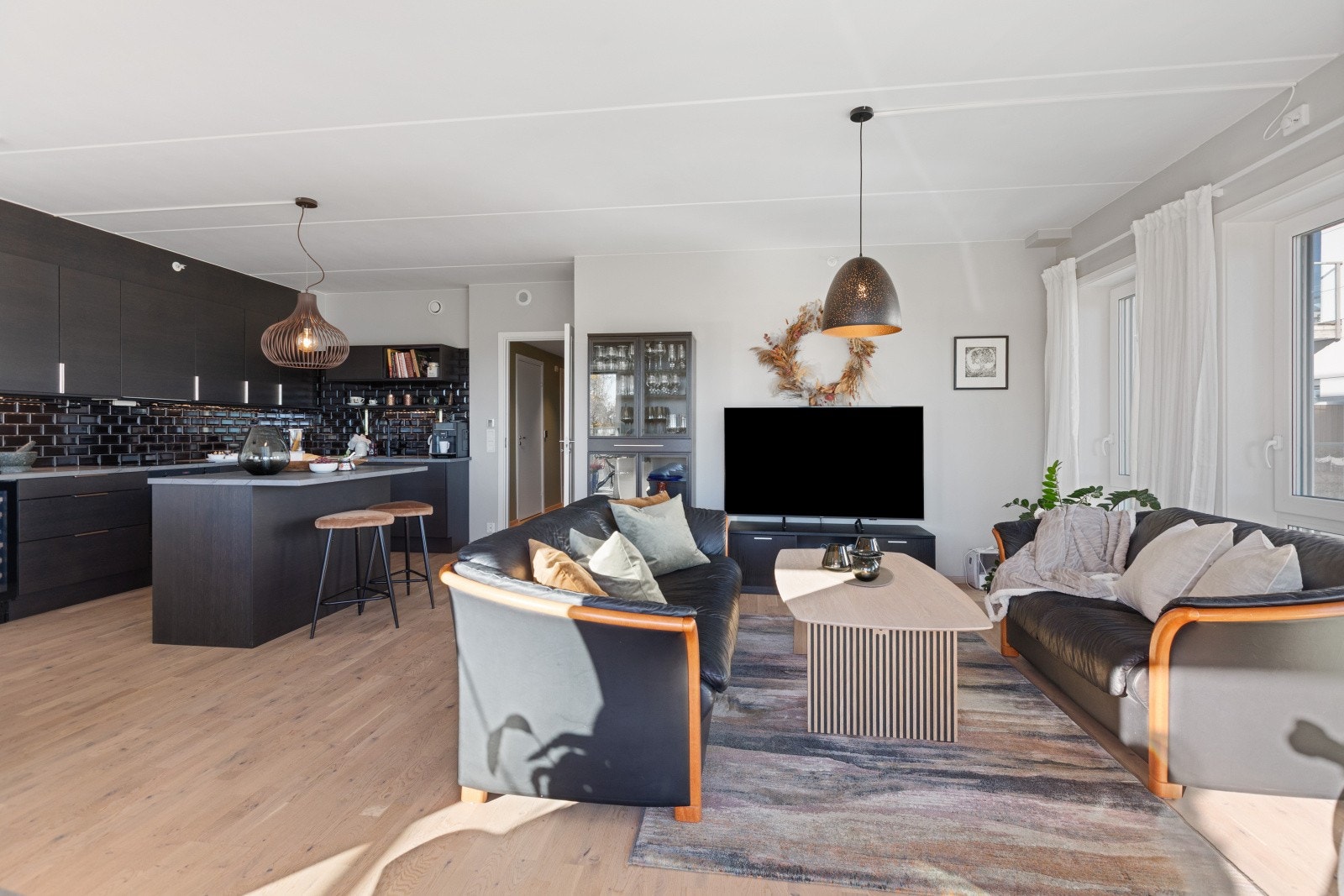 Via en glassdør inntrer vi den åpne kjøkken/stue-løsningen. Galleribilde