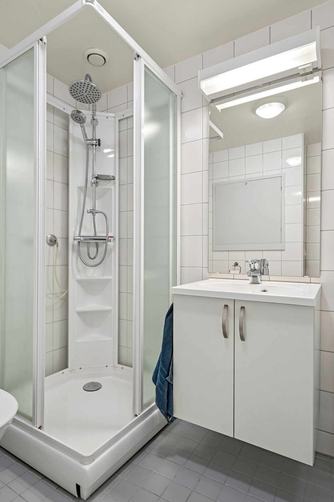 Innredningen består av servant med skap under og vegghengt speil med belysning over Galleribilde