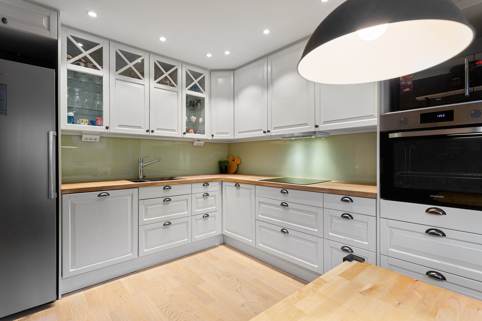 Nisje til frittstående kjøleskap. Integrert stekeovn og oppvaskmaskin. Nedfelt platetopp. Ventilator under overskap. Galleribilde