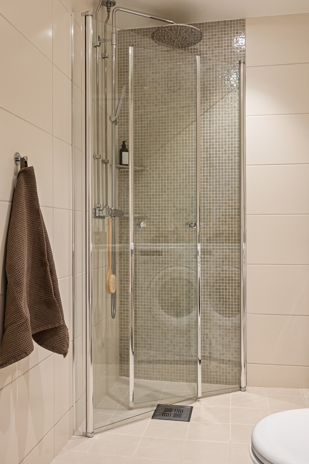 Videre har man dusjhjørne med innfellbare glassdører og dusjarmatur med hånddusj og regndusj. Galleribilde