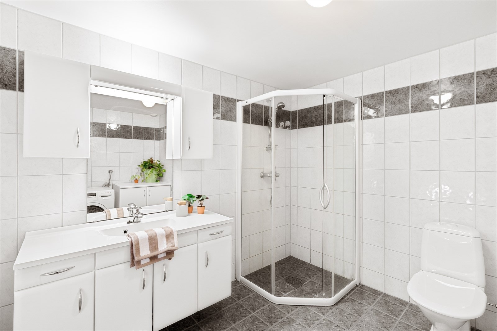 Badet er innredet med god oppbevaringsplass og praktisk vaskerom løsning Galleribilde