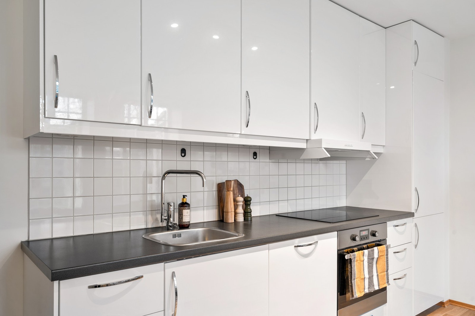 Kjøkkenet inneholder integrerte hvitevarer som platetopp, stekeovn, oppvaskmaskin og kjøl/frys. Galleribilde