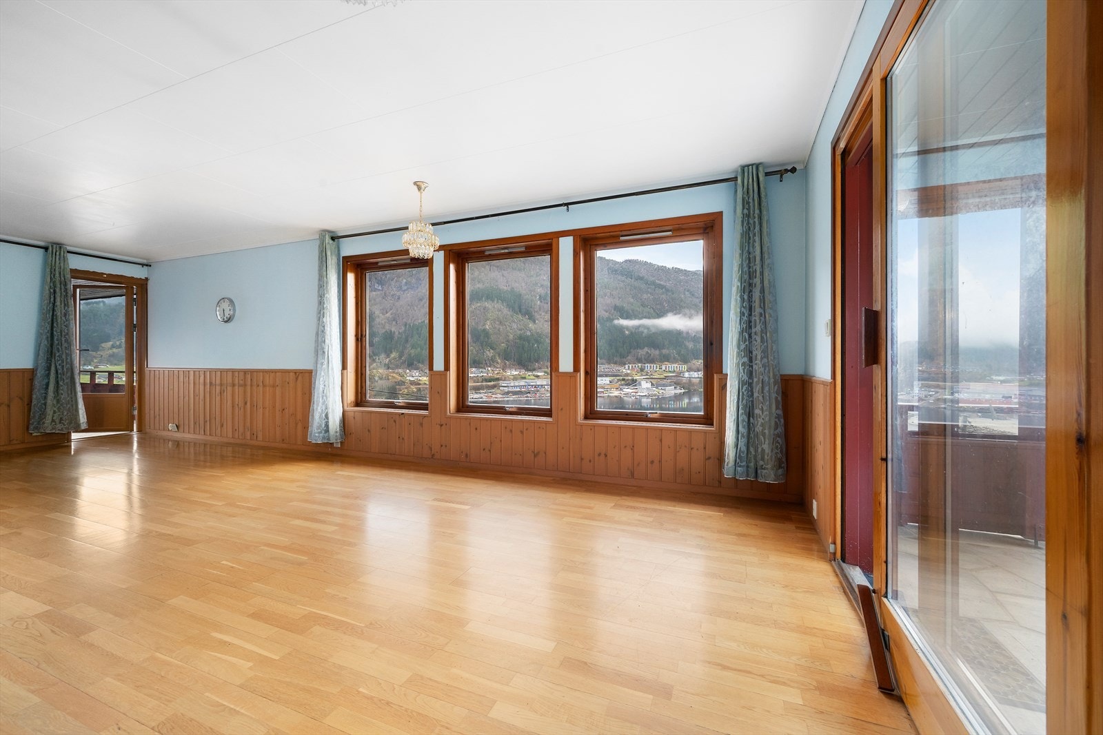 Romslig stue med store vindusflater og utgang til veranda. Galleribilde