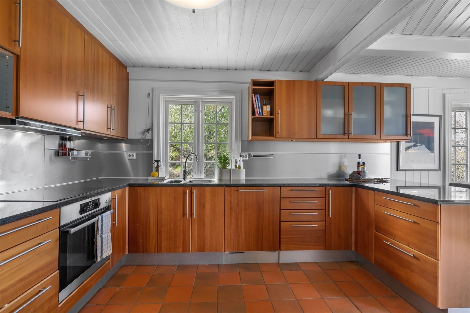 Kjøkkeninnredningen er praktisk utformet og har integrerte hvitevarer. Galleribilde