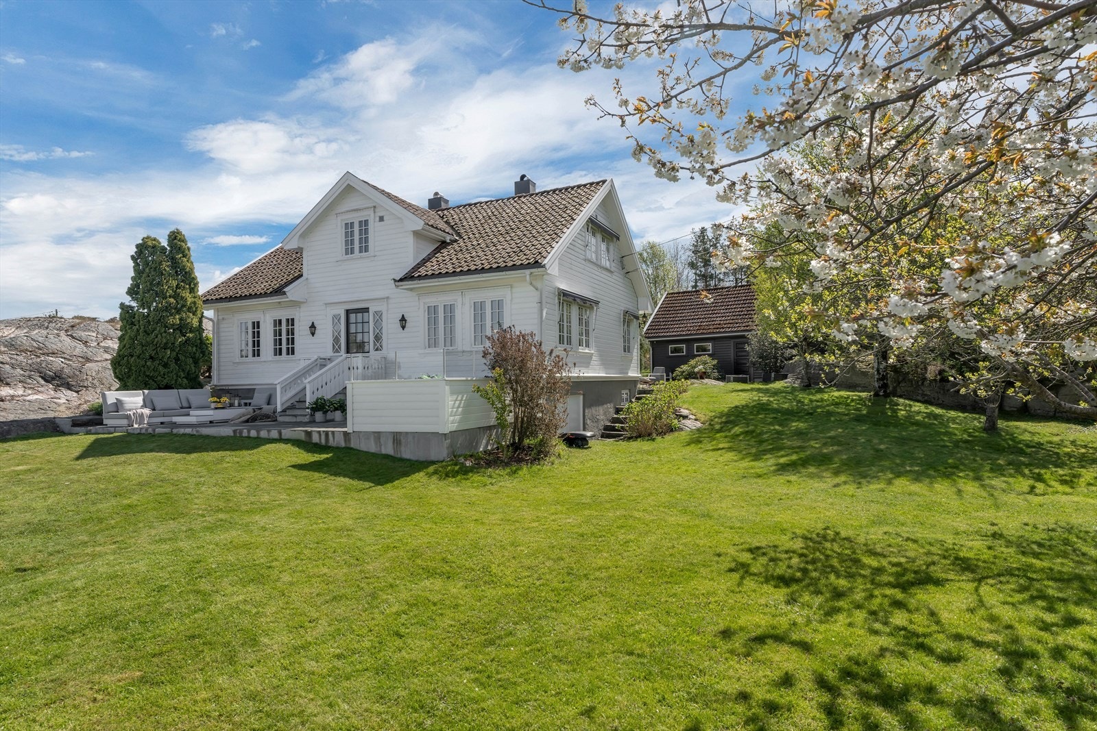 Tomten er idyllisk og parkessig opparbeidet med usjenerte uteplasser og vakker beplantning. Galleribilde