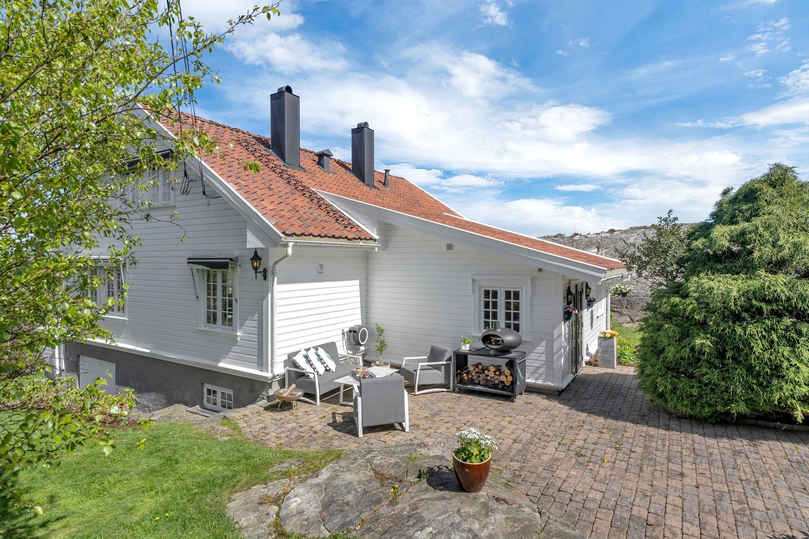 Kombinasjonen av steinbelagte uteplasser, frodig hage og fjell i dagen passer perfekt for beliggenheten. Galleribilde