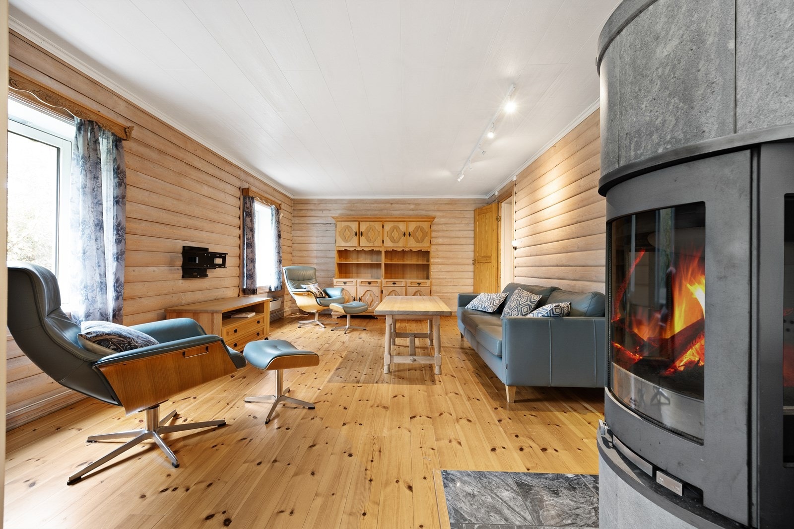 Tv-stua har et lunt preg med liggende rundtømmerpanel på veggene, og furugulv. Galleribilde